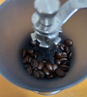 HARIOの手動コーヒーミル「セラミックコーヒーミル・スケルトン」にコーヒー豆を入れた状態